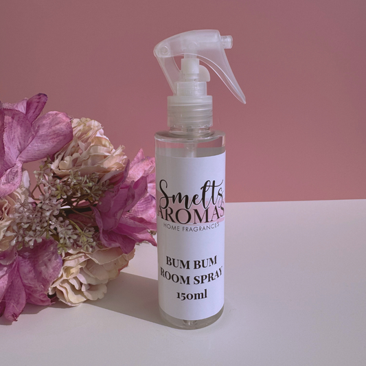 Bum Bum room spray bottle from Smelts Aromas with flowers on a pink background