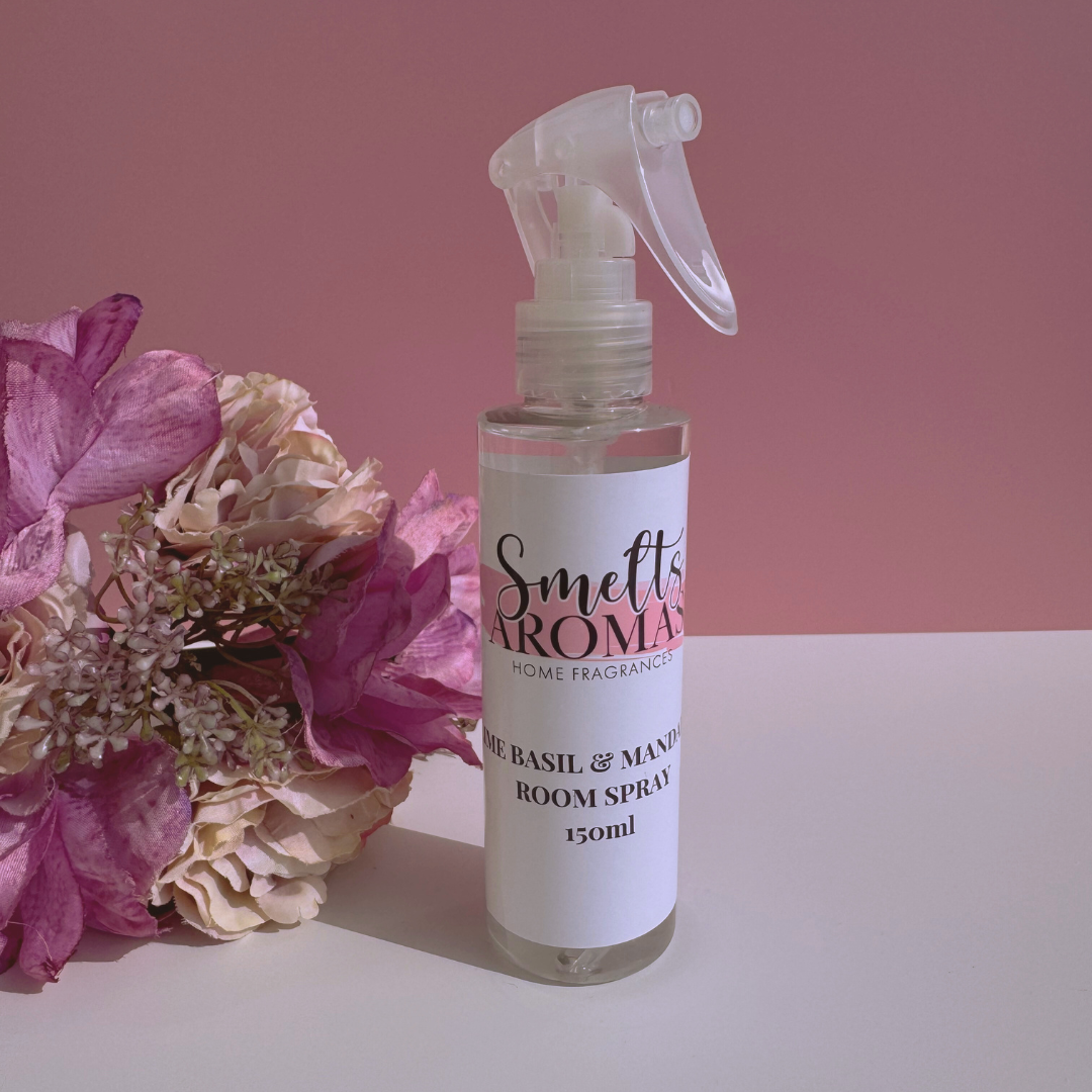 Lime, Basil & Mandarin room spray bottle from Smelts Aromas with flowers on a pink background
