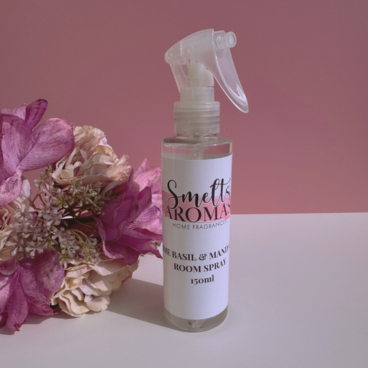 Lime, Basil & Mandarin room spray bottle from Smelts Aromas with flowers on a pink background