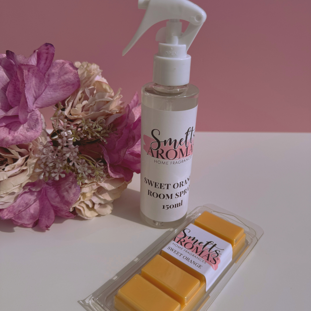 Smelts Aromas Sweet Orange room spray and wax melts bundle deal with a flower in the background with a pink background